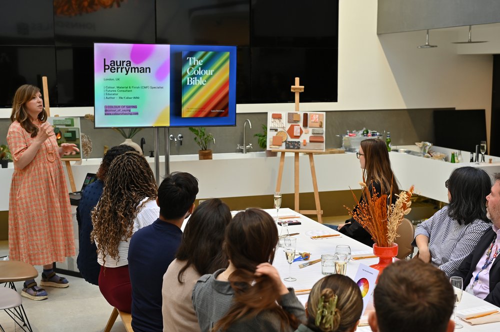 Laura Perryman stands at the front of a long table of designers and architects to present insights from her book, The Colour Bible.